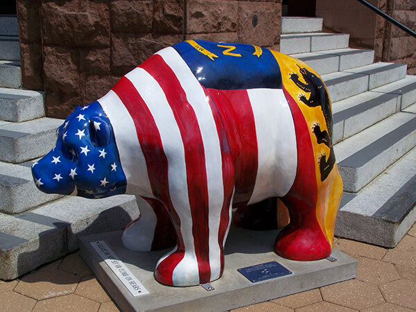 A statue of a bear colored like the US flag